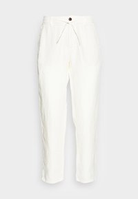 Vita linbyxor med avslappnad passform, dragsko i midjan och en ensam brun knappdetalj upptill. Strukturerad tyg.