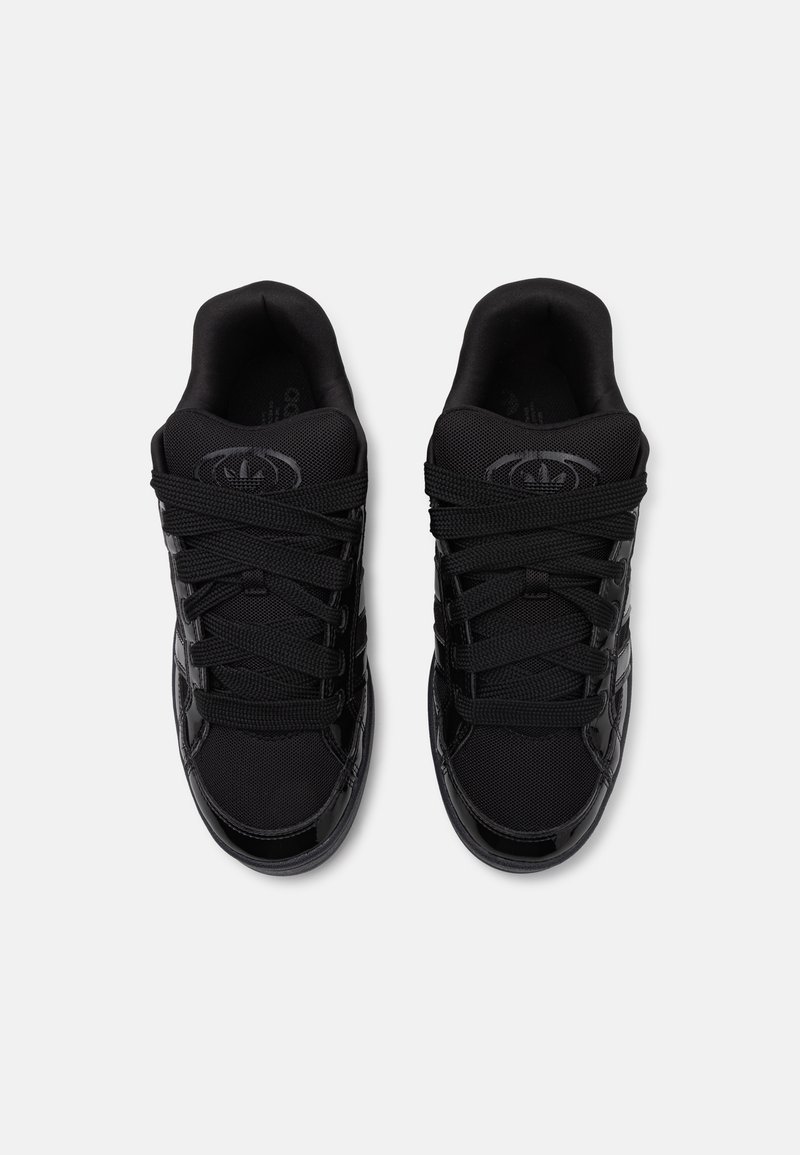 Zapatos deportivos negros hechos de materiales sintéticos, con partes superiores de malla, suelas texturizadas, cordones redondos y un acabado brillante.