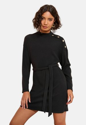 Black ribbed knit dress with long sleeves, high neckline, and belt. Features gold button accents on the shoulder. Textured pattern throughout.