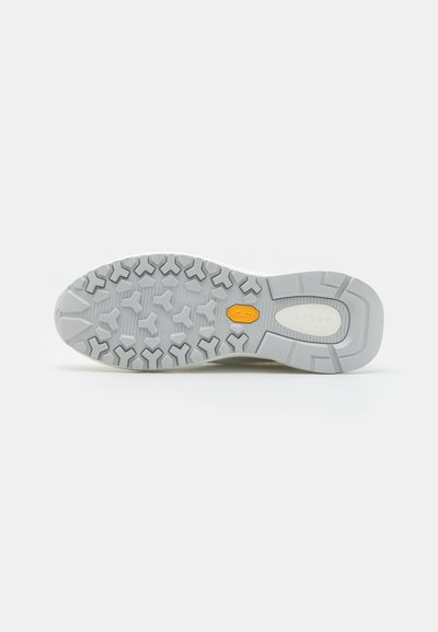 Shoe sole with a gray rubber tread, featuring a herringbone pattern and a yellow Vibram logo; sturdy design for traction and durability.