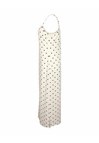 Robe longue blanche sans manches avec des pois noirs, bretelles fines réglables et une fente subtile en bas.