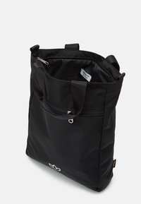 Sac fourre-tout noir en tissu durable, doté d'une poche zippée, de deux poignées et d'un détail logo au bas. Intérieur doublé.