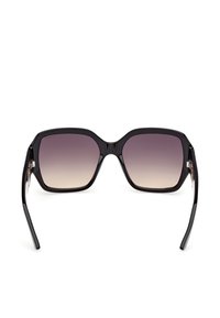 Lunettes de soleil carrées surdimensionnées noires avec des verres dégradés du foncé au clair et des branches fines et courbes sur fond blanc.