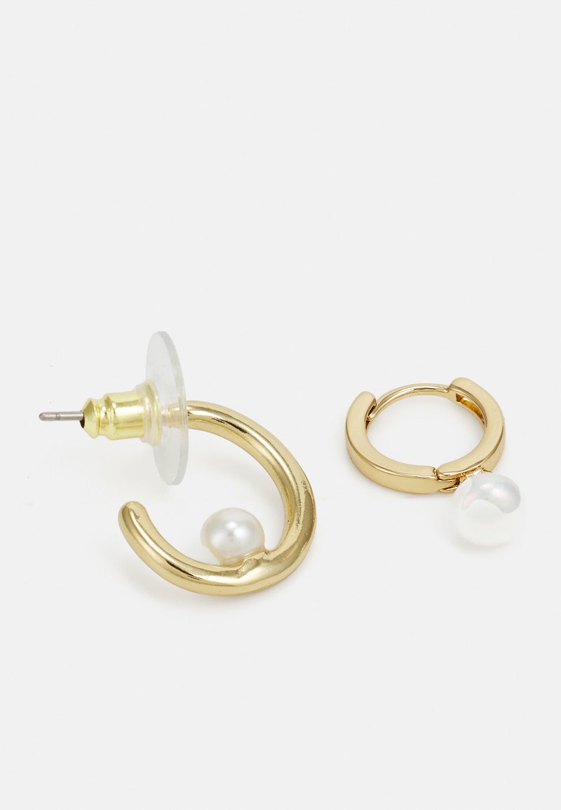 Goldohrringe mit einem geschwungenen Design, der eine mit einem Perlenakzent und klarem Rückteil, der andere in Form eines Creolen mit einem Perelndetail.