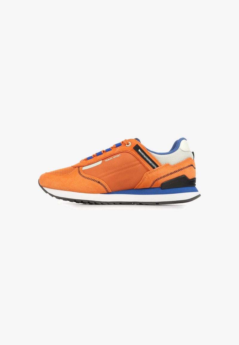Orangefarbener Sneaker mit niedrigem Schaft, blauer und weißer Sohle, blauen Schnürsenkeln, schwarzer Zickzacknaht und dem Schriftzug "TRAVIS SPORT" an der Seite.