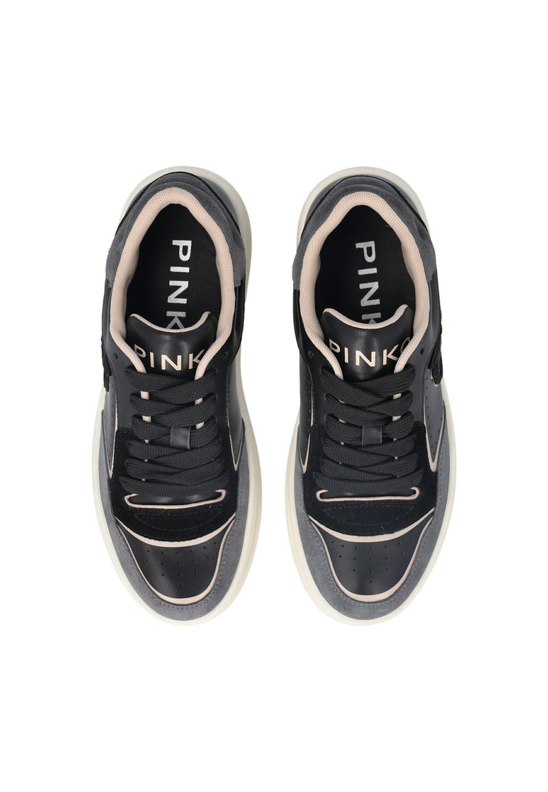 Sneaker in pelle nera e suede grigio con dettagli perforati, accenti beige e suole bianche a contrasto, dotate di lacci e branding all'interno.