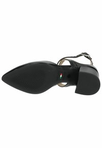 Chaussure en cuir noir à bout pointu avec un petit talon carré, une bride de cheville et une semelle en caoutchouc avec un motif texturé et un détail du drapeau italien.