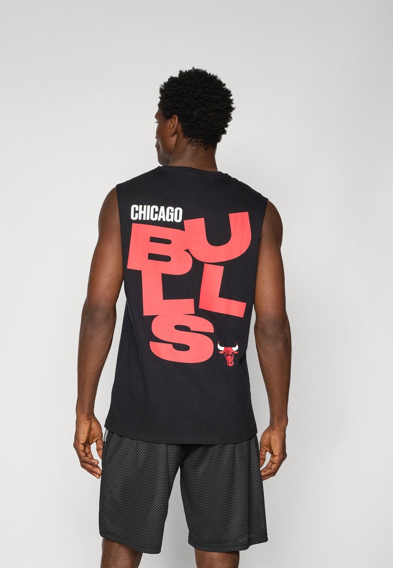 Črna brezrokavna majica s bold rdečim napisom "CHICAGO BULLS"; na dnu blizu roba vsebuje grafiko bika. Nosijo jo s črnimi mrežastimi kratkimi hlačami.