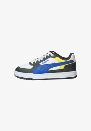 Baskets Puma basses avec base blanche, superpositions noires, bande bleue, accent jaune, lacets blancs et semelle blanche texturée.