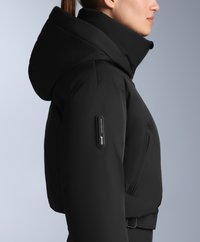 Czarna ocieplana kurtka z wysokim kołnierzem i dużym kapturem. Posiada boczną kieszeń z markowym okuciem oraz dopasowany krój w talii.