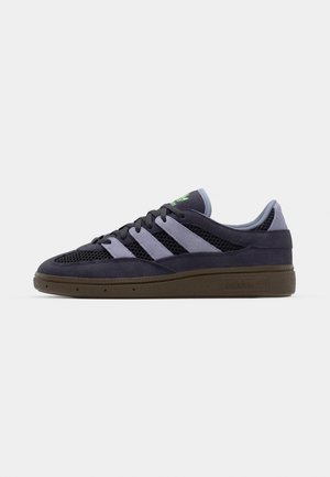 Sneaker blu navy con materiali in rete e suede, caratterizzato da tre strisce blu chiaro, una suola marrone scuro e dettagli del logo verde.