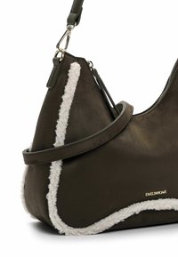 Brown leather handbag with cream faux shearling trim. Features a curved shape, zip closure, and adjustable strap with silver hardware.