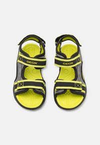 Svarta och gula Geox sandaler med justerbara remmar, strukturerade sulor och perforerade innersulor förandningsförmåga. Lättviktig och sportig design.