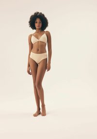 Beiges Bikini-Set mit einem dreieckigen Bralette mit dünnen Trägern und hochgeschnittenen Bikini-Unterteilen, aus glattem, dehnbarem Stoff gefertigt.