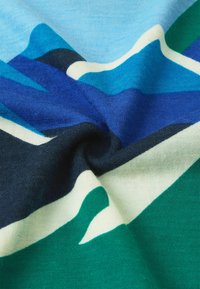 Materiał dzianinowy z falistym wzorem w odcieniach niebieskiego, zielonego, czarnego i białego. Gładka faktura z wyraźnymi przejściami kolorów.