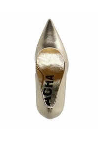 Chaussure dorée à bout pointu avec une finition métallisée brillante et une texture lisse. Dotée d'un dos ouvert et d'une semelle intérieure dorée signée.