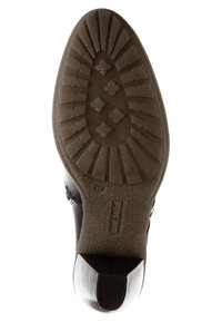 Musta nahkakenkä, jonka pohjassa on teksturoitua kumia paremman pidon takaamiseksi. Kenkässä on pyöristetty kärki ja hopeanvärinen korostus kannassa. Pohjakuvioinnissa on timantinmuotoisia ja viivamaisia kuvioita.