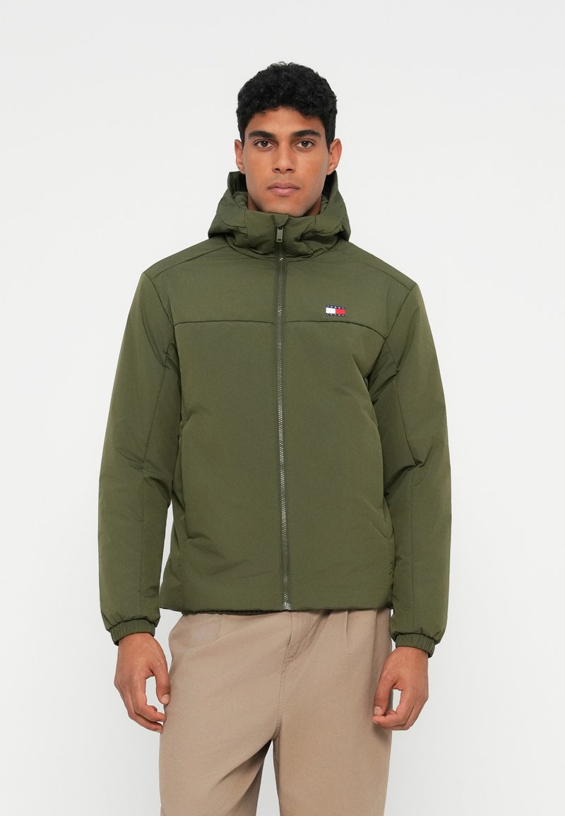 Olive green hooded puffer jacket, zippered front, elastic cuffs, featuring a small logo patch with red, white, and blue details on the chest.