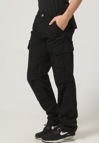 Svarta cargobyxor tillverkade av slitstarkt tyg, med flera fickor, en avslappnad passform och ett knappstängning vid midjan.