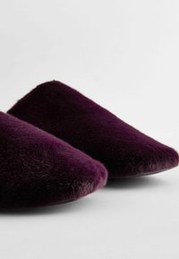 Purple faux fur slip-on shoes with a pointed toe design and a soft, textured surface. Elegant and minimalistic in style.