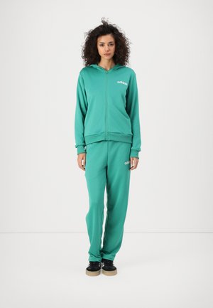 Felpa verde con zip e pantaloni jogger coordinati realizzati in tessuto morbido. Presenta un logo ricamato su entrambi i capi e polsini a costine.