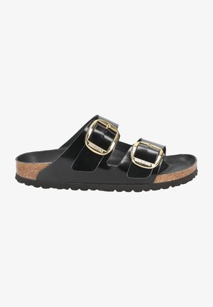 Sandalia Birkenstock negra con plantilla de corcho, dos correas anchas ajustables con hebillas doradas y suela negra texturizada.