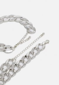 Hõbedane ketikujundusega ehtekomplekt, millel on omavahel seotud lingid ja selge rhinestone'iga, sisaldab panna ja reguleeritavat ketti.