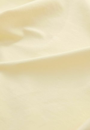 Svijetložuti materijal s glatkom, mekanom teksturom, koja ima suptilni sjaj i minimalni uzorak, prikazujući drapiran, valovit izgled.