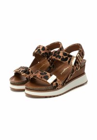 Sandalias de cuña con estampado de leopardo, dos correas ajustables, material de ante marrón, mediopié de corcho y suela exterior de goma blanca. Acentos de hardware dorado.