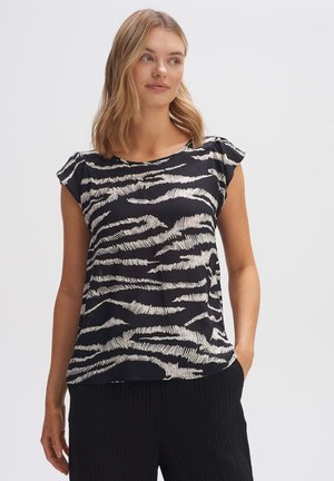 Gestreiftes Oberteil in Schwarz und Weiß mit kurzen Ärmeln. Der Stoff ist leicht und glatt und weist ein dezentes Zebra-Muster auf. Mit runder Halslinie.