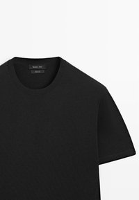 T-shirt noir en coton à manches courtes avec col rond, étiquette de marque visible à l'intérieur du col indiquant "Massimo Dutti".