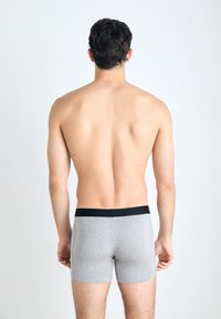 Gray fabric boxer shorts with a black waistband, featuring a snug fit and smooth texture. View from the back, showing no other details.