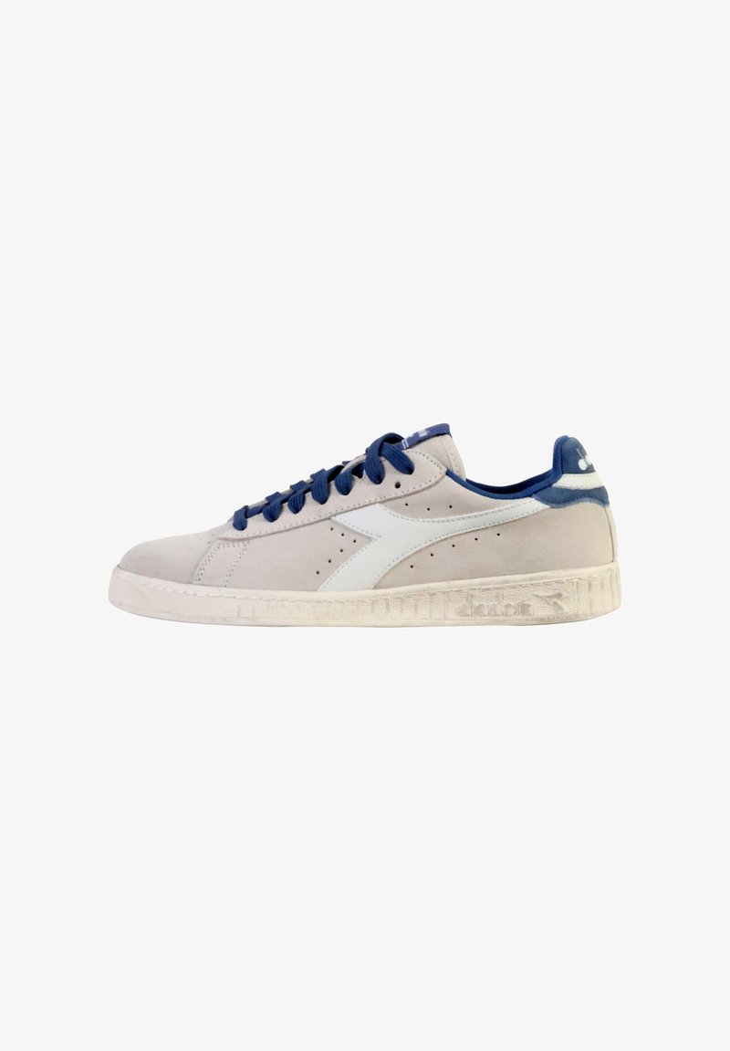 Zapatillas de ante en gris claro con detalles en azul marino. Presentan cordones redondos, perforaciones y una suela de goma texturizada con detalle del logo.