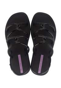 Sandali neri con tre cinturini intrecciati, realizzati in materiale testurizzato, dotati di una suola piatta e di un'etichetta viola del marchio sulla soletta.