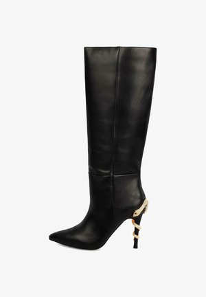 Botas de cuero negras hasta la rodilla con puntera afilada y un acento en forma de serpiente dorada en el tacón. Textura suave, diseño ajustado.