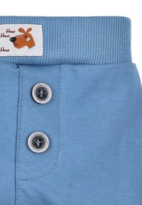 Blå bomullsshorts med en ribbad midja, två grå knappar och en etikett med en tecknad hunddesign.