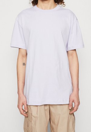 T-shirt court à manches courtes couleur lavande clair, fabriqué en coton doux, présentant un col rond classique et une coupe décontractée, sans motif ni accents visibles.