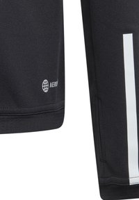 Zwarte sportshorts van ademend materiaal, met een witte verticale streep en een klein logo in wit aan de zoom.