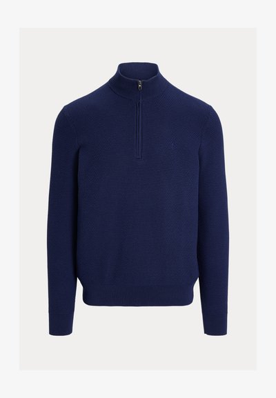 Tengerészkék, texturált kötött pulóver negyedcipzáras gallérral, bordázott mandzsettával és szegéllyel, fehér háttéren bemutatva.