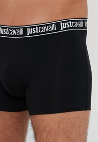 Czarne bokserki z białą i czarną elastyczną talią z logo "Justcavalli". Wykonane z gładkiego, elastycznego materiału dla wygody.