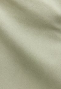 Helle beige Stoff mit glatter Textur und diagonalem Rippmuster, das Baumwolle oder Polyester ähnelt.