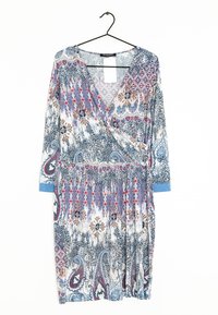 Blommönstrad omslagklänning med långa ärmar, featuring en blandning av blå, röd och beige nyanser, tillverkad av lättviktig tyg. Hänger på en svart krok.