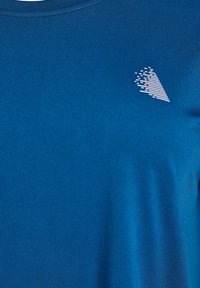 Modrá krátkorpásková tričko vyrobené z jemného materiálu, s malým bielym grafickým dizajnom na ľavej hrudi. Hladká textura, okrúhly výstrih.