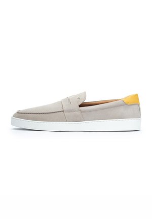 Zapatos de ante tipo slip-on en gris claro con un acabado texturizado. Presentan un acento en el talón amarillo y una suela de goma blanca para mayor durabilidad.