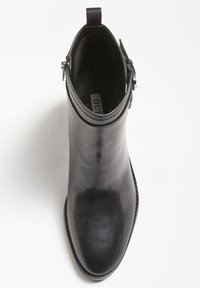 Černá kožená kotníková bota s kulatou špičkou, malým podpatkem, bočním zipem a poutkem na nazouvání. Hladká textura a minimalistický design.