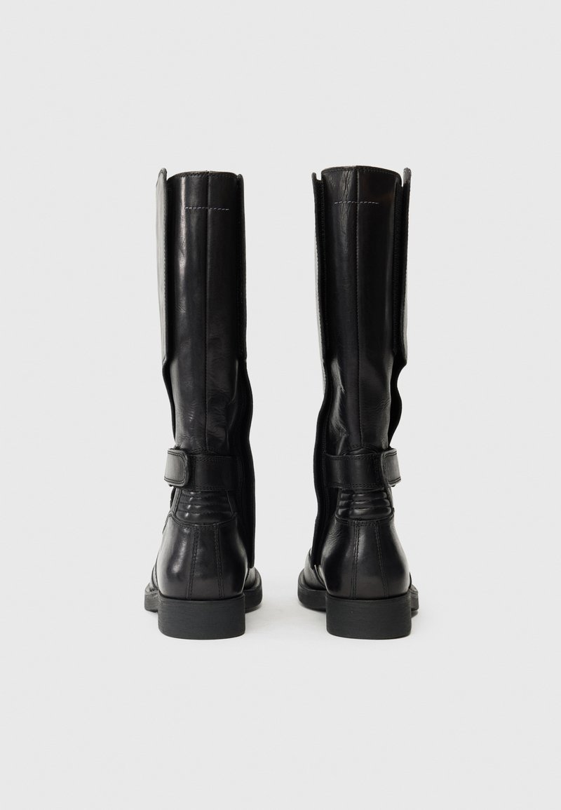 Bottes noires en cuir montantes avec une texture lisse, présentant un détail de bande et un petit talon épais. La vue arrière montre les coutures latérales et les points de couture.