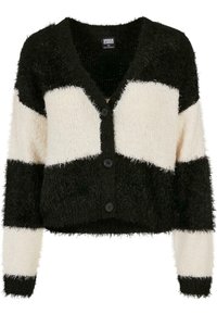 Stickad cardigan med svarta och krämfärgade horisontella ränder, med en mjuk, fluffig textur, V-krage och fem svarta knappar framtill.