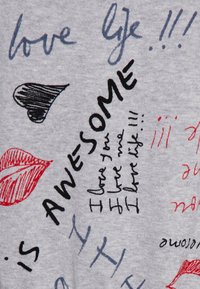 Tissu gris avec texte et graphiques imprimés. Comprend des lèvres noires et rouges, diverses phrases manuscrites et des gribouillages ludiques.