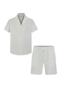 Chemise blanche à manches courtes avec un col et un short assorti avec une taille élastique. Tissu doux et léger, design minimal.