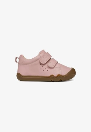 Pink toddler shoes with a smooth leather exterior, two Velcro straps, and a brown rubber sole featuring a wavy pattern. Ventilation holes present.